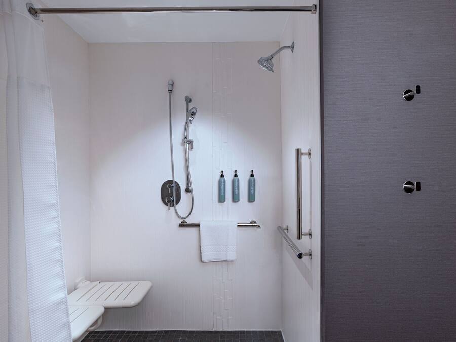 Un baño moderno con ducha, inodoro y barra para toallas.