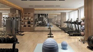 Una palestra moderna con tapis roulant, pesi liberi e palle da ginnastica.