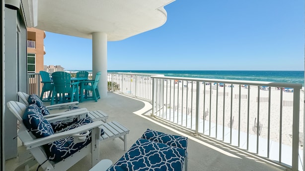 Ein Balkon mit Blick auf Strand und Meer.