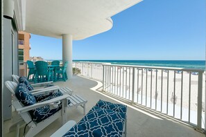 Een balkon met uitzicht op het strand en de oceaan.