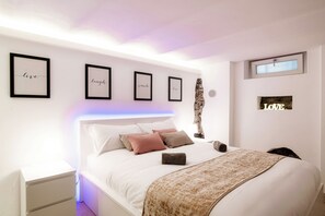 A modern bedroom with a bed, white nightstands, and framed inspirational quotes on the wall. - Lake Como Love (Como)