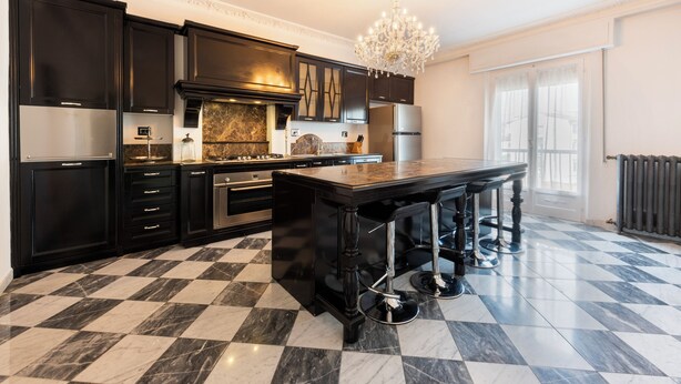 A modern kitchen with dark cabinetry, a marble countertop, and a central island. - Ippopotamo by Mmega (Florence)