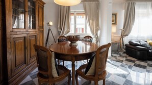 A dining area with a wooden table and chairs, a large wooden cabinet, and a chandelier. - Ippopotamo by Mmega (Florence)