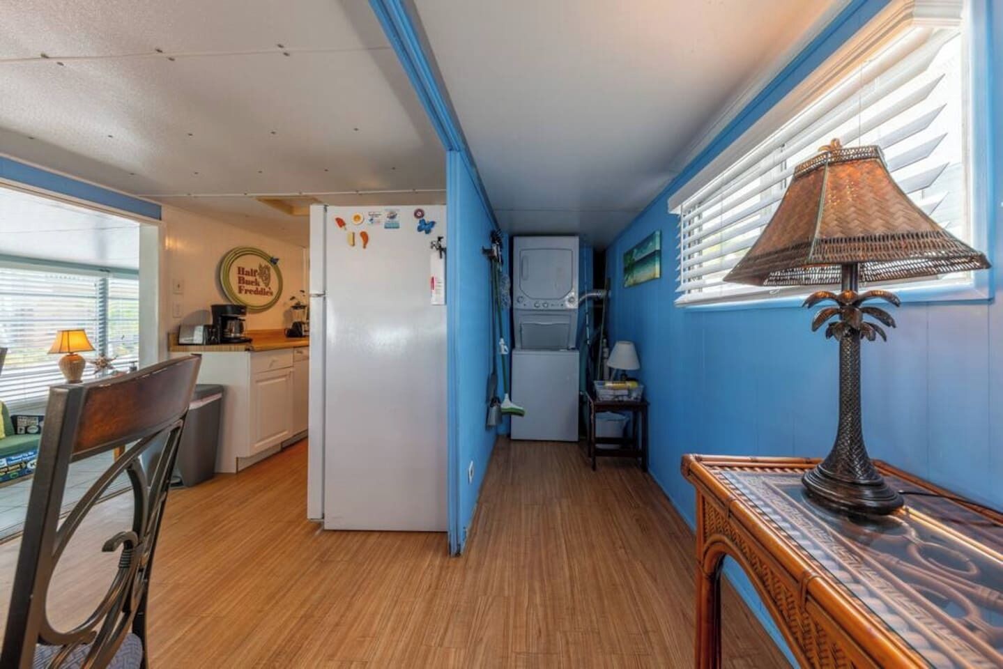 A compact kitchen with a refrigerator, microwave, and a dining area with a chair and table.