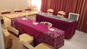 A conference room with a long table, chairs, and a projector screen. - Hotel Southern Grand (Vijayawada)