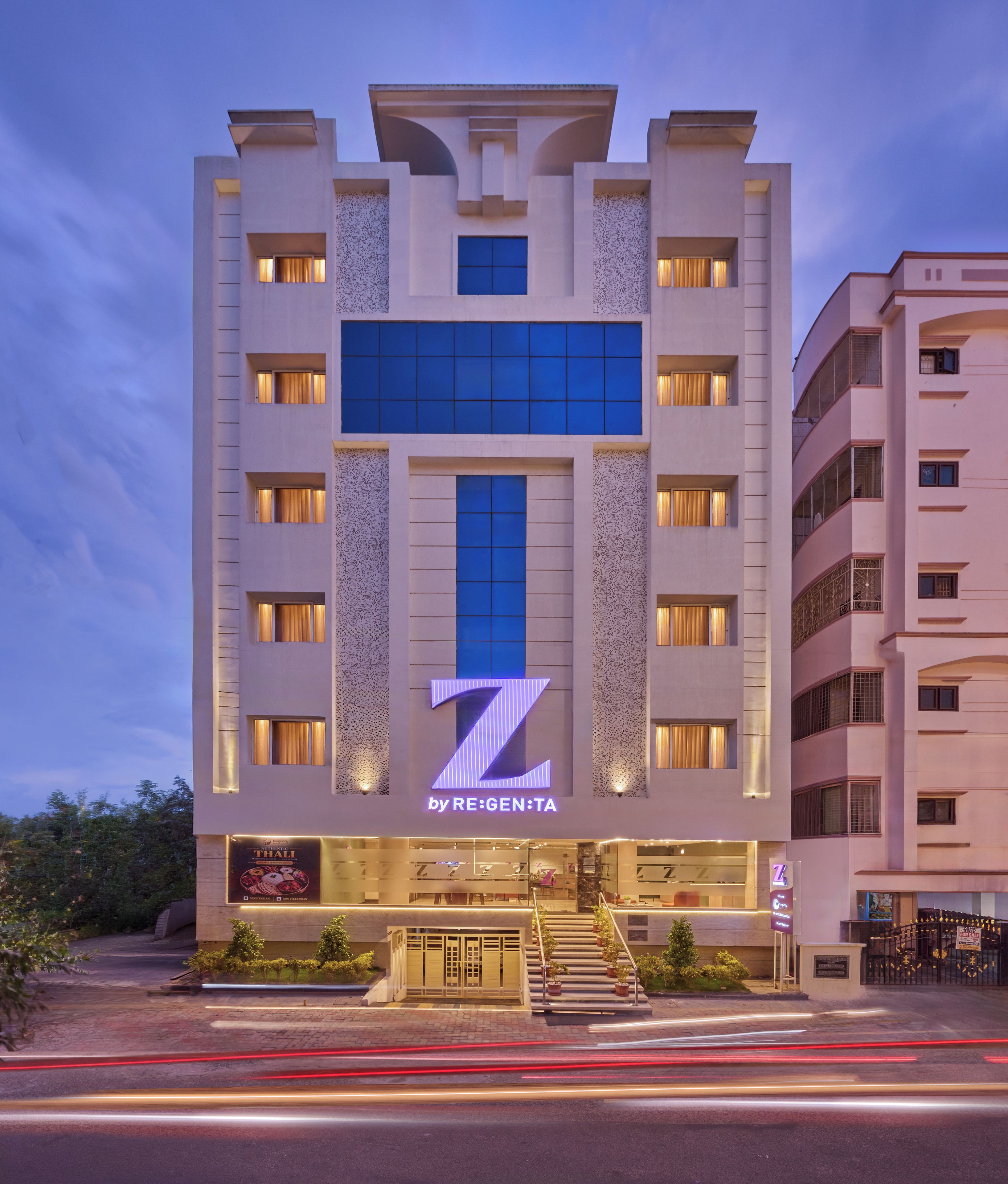 A multi-story hotel with a prominent 'Z' logo on the facade, featuring a modern architectural design with large windows and a central entrance.