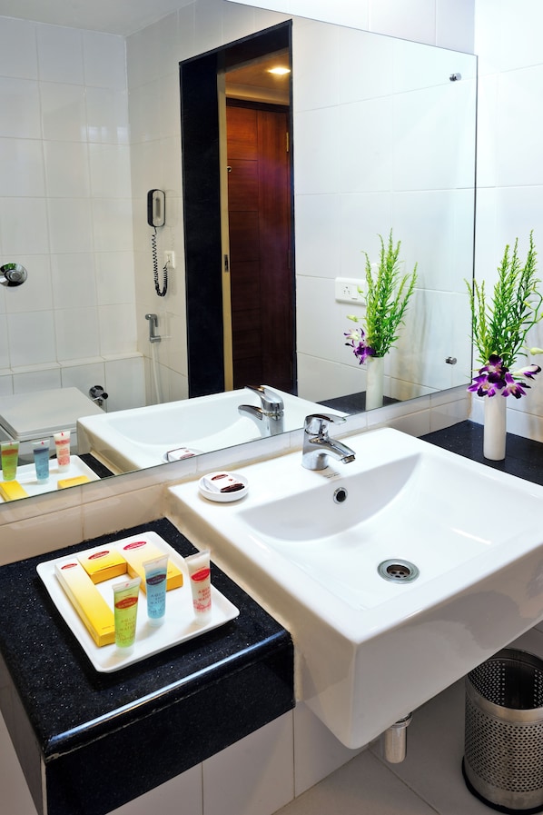 A modern bathroom with a large mirror, two sinks, and a vanity with toiletries. - Z by Regenta Vijayawada (Vijayawada)