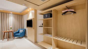 A modern room with a wooden wardrobe, a flat-screen TV, and a blue armchair.