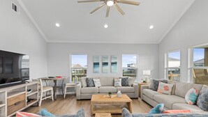 A spacious living room with a sofa set, coffee table, and TV. - Steps to the Beach • Hot Tub • Modern 5★ Crystal Beach Getaway (Crystal Beach)