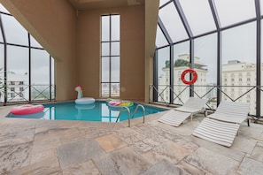 An indoor swimming pool with lounge chairs and a lifebuoy.