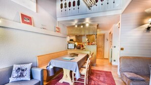 A cozy room with a dining table, a sofa, and a couch. There is a kitchen area with cabinets and a microwave. - 2nd floor, balcony, tv, ski locker, 40m², Les Gets (Les Gets)