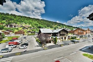 A mountain resort with wooden buildings, a main road, and a parking area.