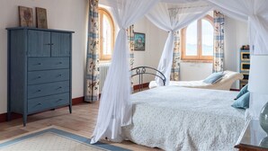 Une chambre à coucher avec un lit, une armoire et une fenêtre avec des rideaux.