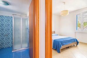 A bedroom with a bed, a window, and a shower area with a tiled wall. - 3917 Villetta Giardino dei Pini by Barbarhouse (Alliste)