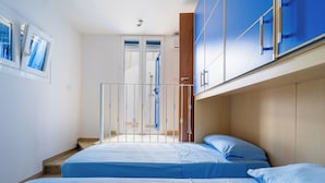 A bedroom with two beds, a wooden headboard, and a view of a balcony. - 3917 Villetta Giardino dei Pini by Barbarhouse (Alliste)