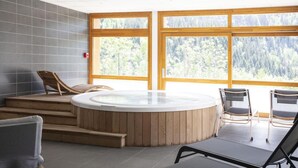 Zona de spa con hidromasaje, escalones de madera y asientos.