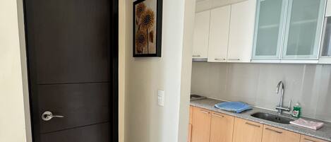 A modern kitchen with white cabinets, a sink, and a countertop.