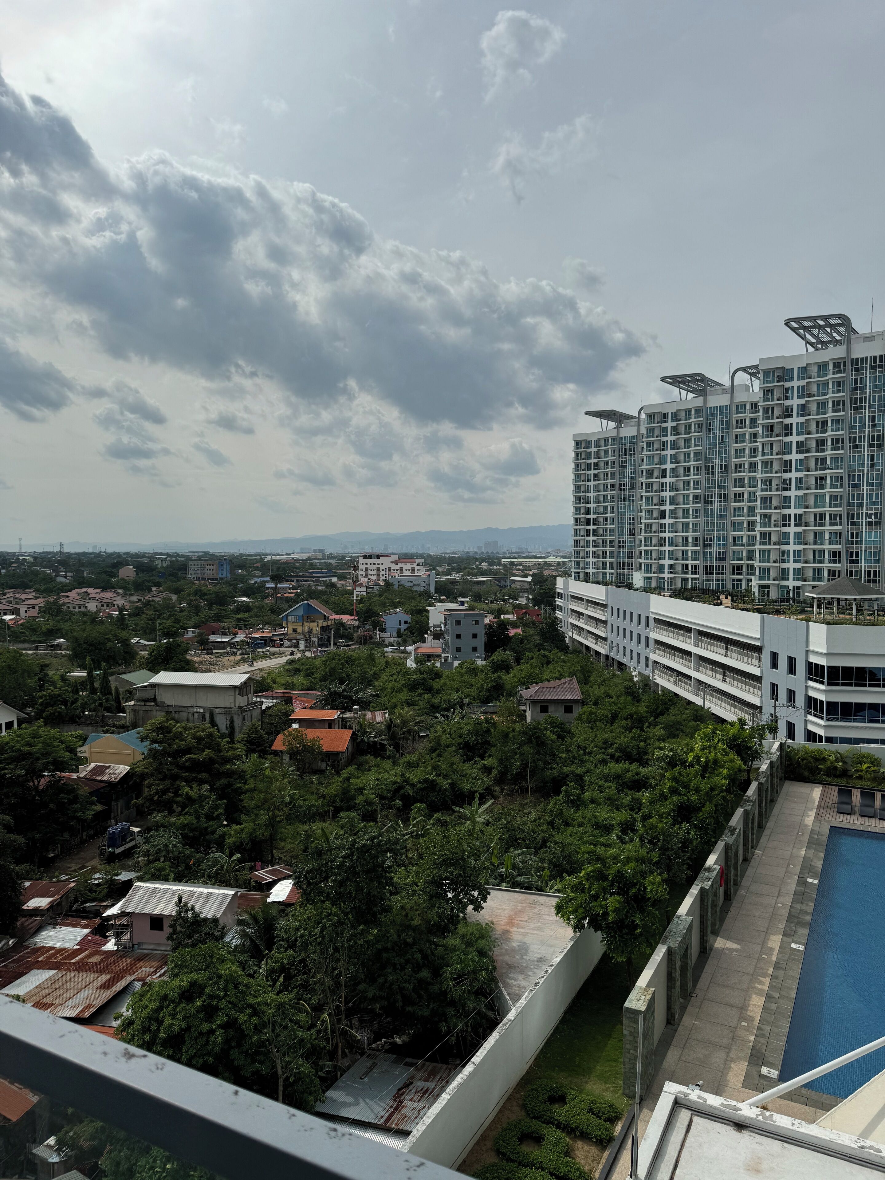Un immeuble de grande hauteur doté de nombreux balcons et d’une piscine.