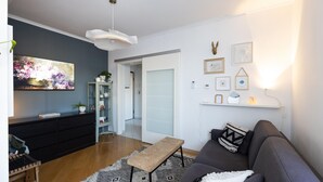 A modern living room with a grey sofa, a coffee table, a rug, and a painting on the wall.