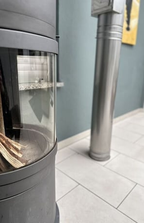 A trash can with a transparent lid, a metal pole beside it, and a tiled floor. - Milan Modern Retreat (Xanten)