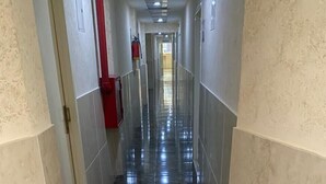 Un couloir doté d’un sol en marbre noir brillant et de murs aux couleurs claires.