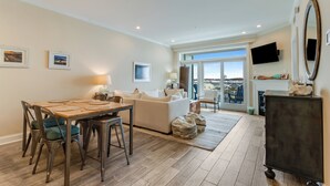 Ein modernes Wohnzimmer mit Essbereich, einer Couch und einem Kamin.