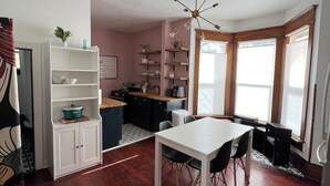A modern kitchen with white cabinetry, a dining table, and a built-in oven. - Downtown Studio: Close to CC (Colorado Springs)