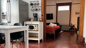 A compact living space with a kitchenette, a bed, a TV, and a dining area. - Downtown Studio: Close to CC (Colorado Springs)