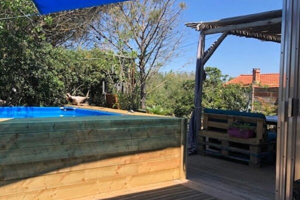A wooden deck with a pool, surrounded by trees and a pergola. - Atypical, set on the beach with direct access, swimming pool, barbecue, pets allowed (Marseillan)