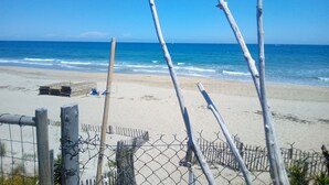 A beach with a wooden fence and a clear view of the ocean. - Atypical, set on the beach with direct access, swimming pool, barbecue, pets allowed (Marseillan)