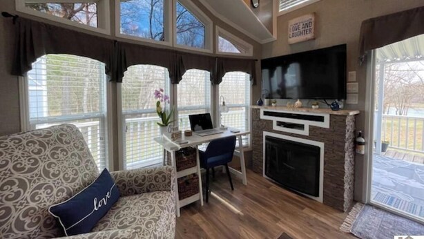 A living room with a fireplace, a TV, and a sofa with a cushion.