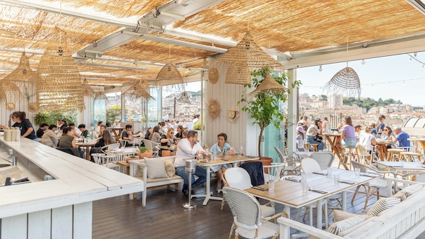 An outdoor dining area with wicker furniture and a thatched roof. - Les Appartements de Babel Vieux Port (Marseille)