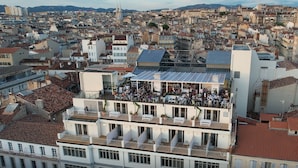 A multi-story building with a rooftop terrace hosting a social event. - Les Appartements de Babel Vieux Port (Marseille)