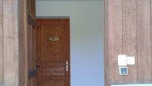 A wooden door with a metal handle and a small window above it. - Aux Portes des Volcans D'auvergne, de la Rivière Dordogne et de ses Barrages (Champagnac)