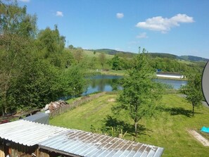 Escape to a serene rural retreat surrounded by lush greenery and a tranquil body of water.