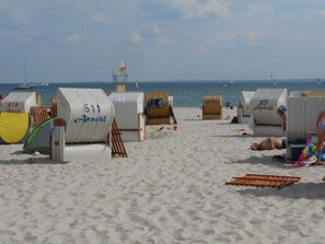 Beach huts numbered 310 and 511 with a view of the sea and boats in the background. - Seaview The House by the sea (Groemitz)