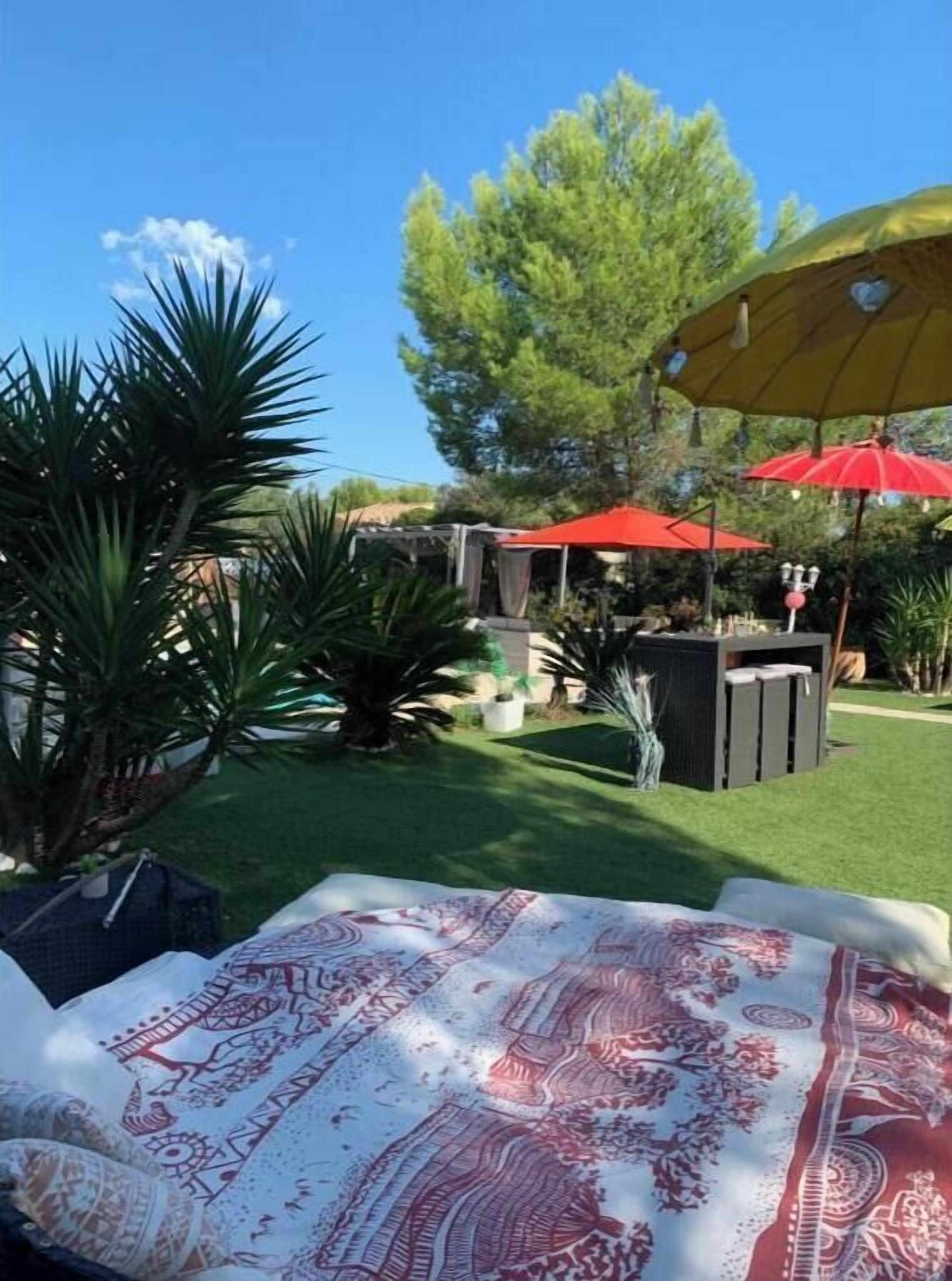 Una zona patio con tovaglia a motivi, ombrelloni e un piccolo angolo salotto.