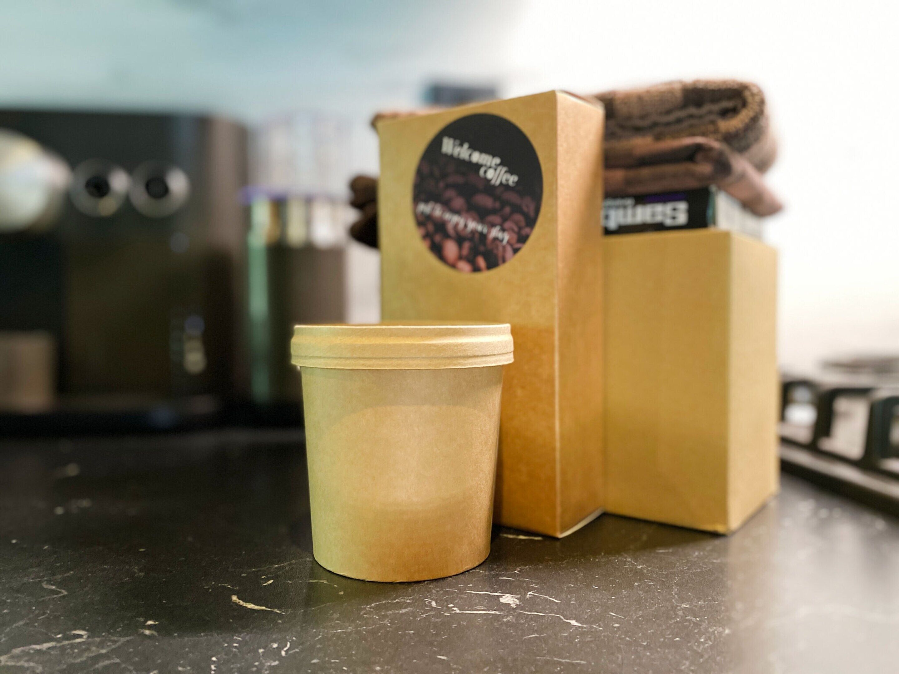 A coffee cup and a box of coffee beans on a counter.