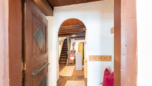 A wooden door with a decorative panel, a hallway with a rug, and a staircase leading to another room. - Farmhouse Bramberg Near Wildkogelbahn (Bramberg am Wildkogel)