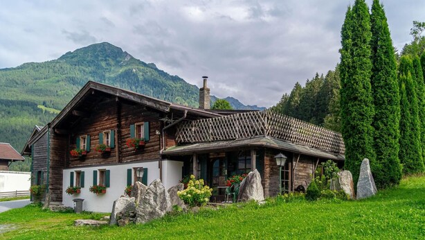 A traditional wooden chalet with a sloped roof, large windows, and a stone chimney. - Farmhouse Bramberg Near Wildkogelbahn (Bramberg am Wildkogel)