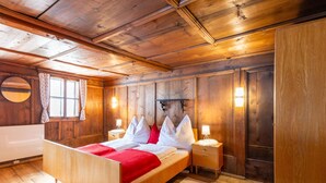 A wooden cabin bedroom with a bed, nightstands, and a large mirror. - Farmhouse Bramberg Near Wildkogelbahn (Bramberg am Wildkogel)