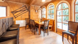 A wooden interior with a dining area, benches, and arched windows. - Farmhouse Bramberg Near Wildkogelbahn (Bramberg am Wildkogel)