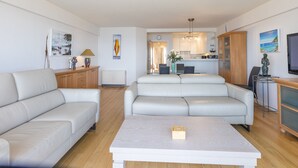 Un salon moderne comprenant un canapé, une table basse et un coin repas avec des chaises.