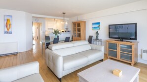 Un salon moderne avec un canapé, une table à manger et un téléviseur.