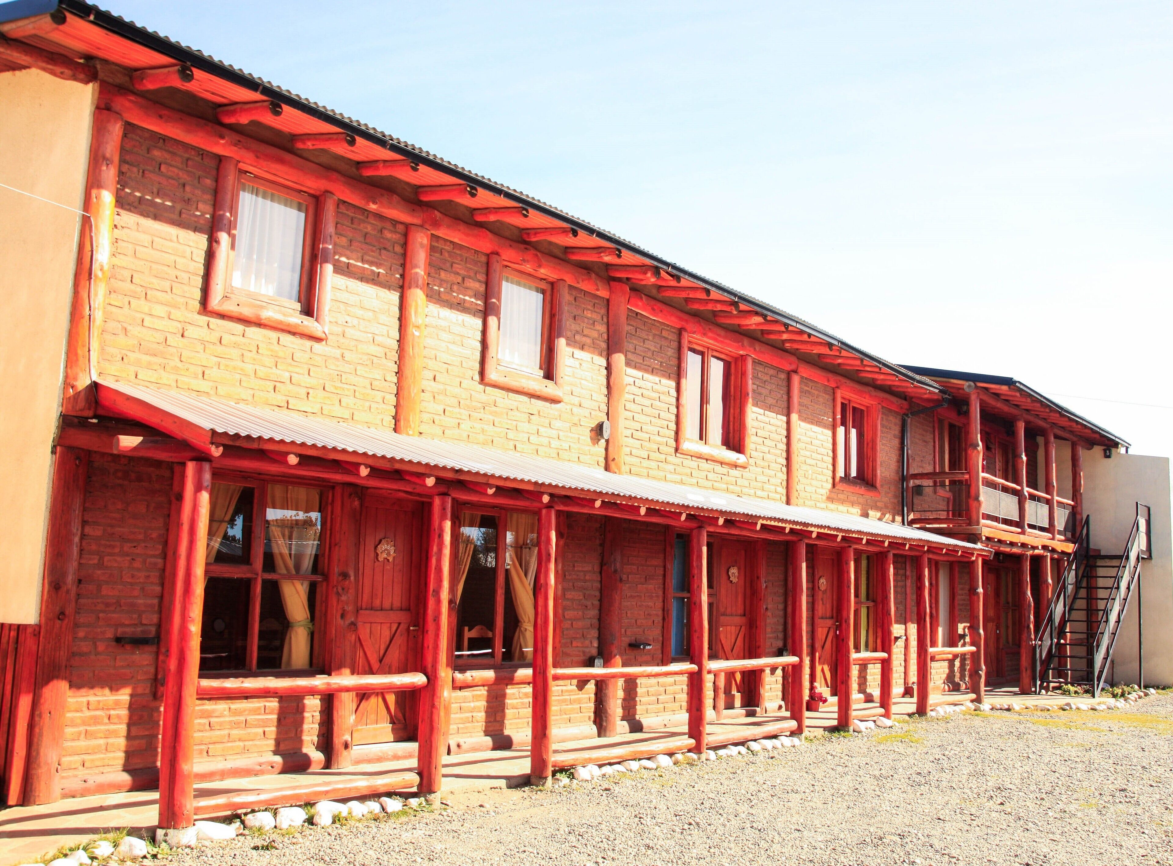 A two-story building with a red exterior and a covered porch.