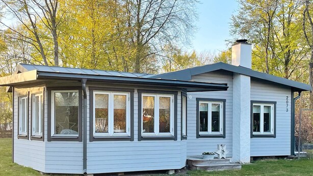 A single-story house with a gabled roof, large windows, and a chimney. - 4 Star Holiday Home in Solvesborg (Sölvesborg)