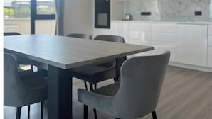 Moderni keittiö, jossa on valkoiset kaapit, marmorista tehty välitila ja suuri ikkuna.