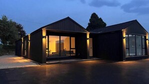 Un edificio moderno con ventanas amplias y un área exterior techada.