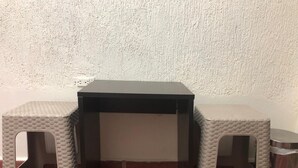 Un petit bureau de couleur sombre, avec un mur blanc en arrière-plan.