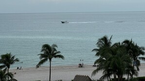A beach with palm trees, a boat on the water, and people on the sand. - 7th FL spacious 1 bedroom  (Hollywood)